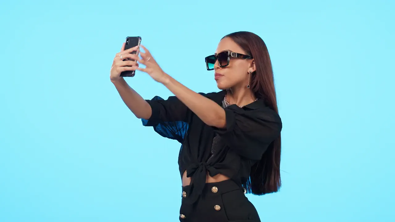A creator in sunglasses filming a selfie video on her phone